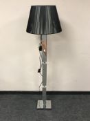 A contemporary mirrored standard lamp with shade,