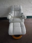 A pair of cream leather swivel armchairs and stools