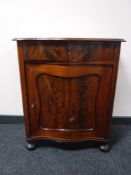A late 19th century mahogany serpentine fronted cupboard