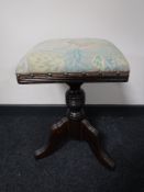 An antique mahogany adjustable stool on tripod base and a walking cane with badges