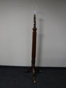 An antique mahogany standard lamp on three way support