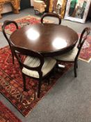 A reproduction mahogany circular dining table (diameter 120cm) and four balloon backed chairs