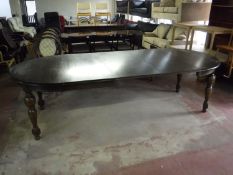 A circular oak extending table and three leaves