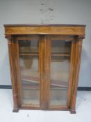 A late 19th century mahogany and walnut double door bookcase with pillar column supports