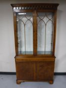 An inlaid yew wood double door bookcase fitted a cupboard beneath
