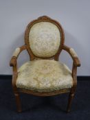 A French walnut salon armchair in a gold fabric