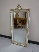 A white and gilt framed hall mirror