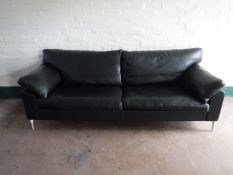 A black leather two seater settee on chrome legs