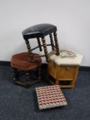 A hexagonal upholstered stool and three other stools