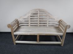 A plantation teak scroll arm garden bench