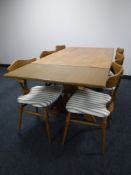 A blonde oak dining table with two leaves on X frame support and six chairs