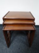 A nest of three teak tables