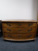 An antique oak bow-fronted three drawer chest