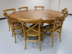 An impressive circular hardwood dining table to seat eight people,