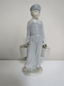 A Lladro figure of a boy carrying two pails