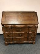An early 19th century continental serpentine front oak bureau, width 115cm,