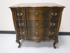 An oak serpentine fronted three drawer chest with metal handles
