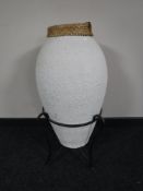 A contemporary wicker and pottery vase on metal stand