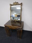 An nest of four walnut glass topped tables and a gilt framed mirror