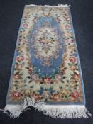 A fringed Chinese rug on blue ground