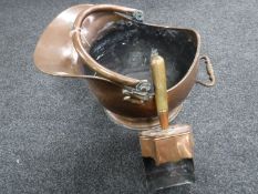 An antique copper coal helmet with shovel