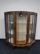 A shaped walnut display cabinet