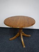 A circular pine pedestal kitchen table