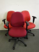 Four red office swivel armchairs