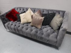 A contemporary three seater settee, upholstered in a button fabric,