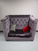 A contemporary high backed settee, upholstered in a mauve button fabric,