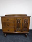 An oak double door sideboard with carved panel doors