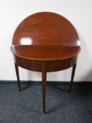 An antique mahogany foldover card table