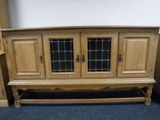A blonde oak four door sideboard