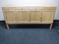 A mid 20th century blonde oak four door sideboard
