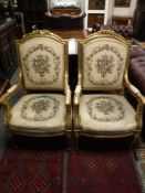 A pair of reproduction of 20th century gilded salon armchairs