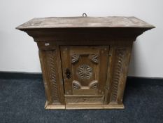 A 19th century carved pine single door wall cabinet