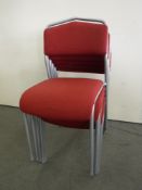 Five red stacking office chairs