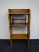 A set of narrow oak open shelves and a book trough