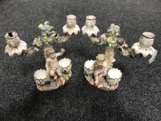 A pair of continental porcelain twin branch candelabrum decorated with putti
