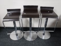 A set of three chrome gas lift bar stools,