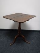 An antique oak tilt top pedestal occasional table