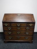 A Georgian oak writing bureau fitted six drawers on bracket feet