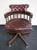 A red button leather Chesterfield swivel captains armchair