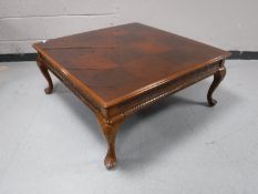 A square mahogany coffee table on cabriole legs