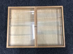 A pine double door curio cabinet with glass shelves