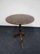 A circular Victorian mahogany tilt top pedestal table