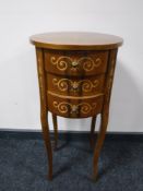 A circular inlaid mahogany three drawer bedside chest