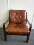 A late 20th century armchair in brown button leather