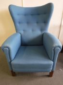 A mid 20th century wing back armchair in blue fabric