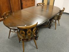 An Ercol extending dining room table, extended length 215 cm and four dining chairs.